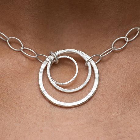 a beautiful and unique handmade sterling silver statement necklace, modelled on brown skin.