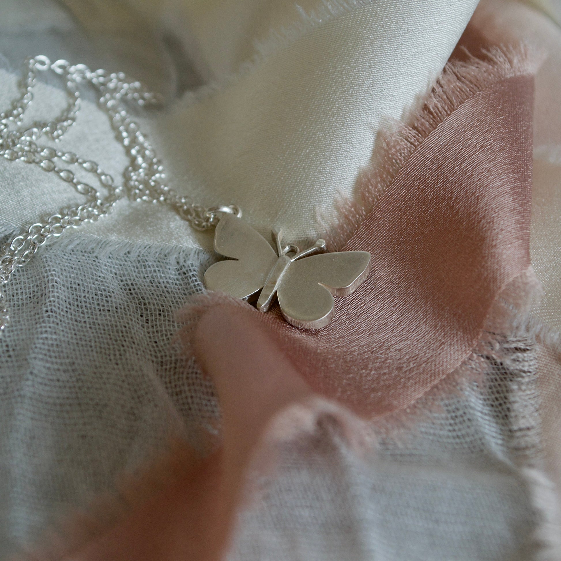 Butterfly necklace on a textured fabric background