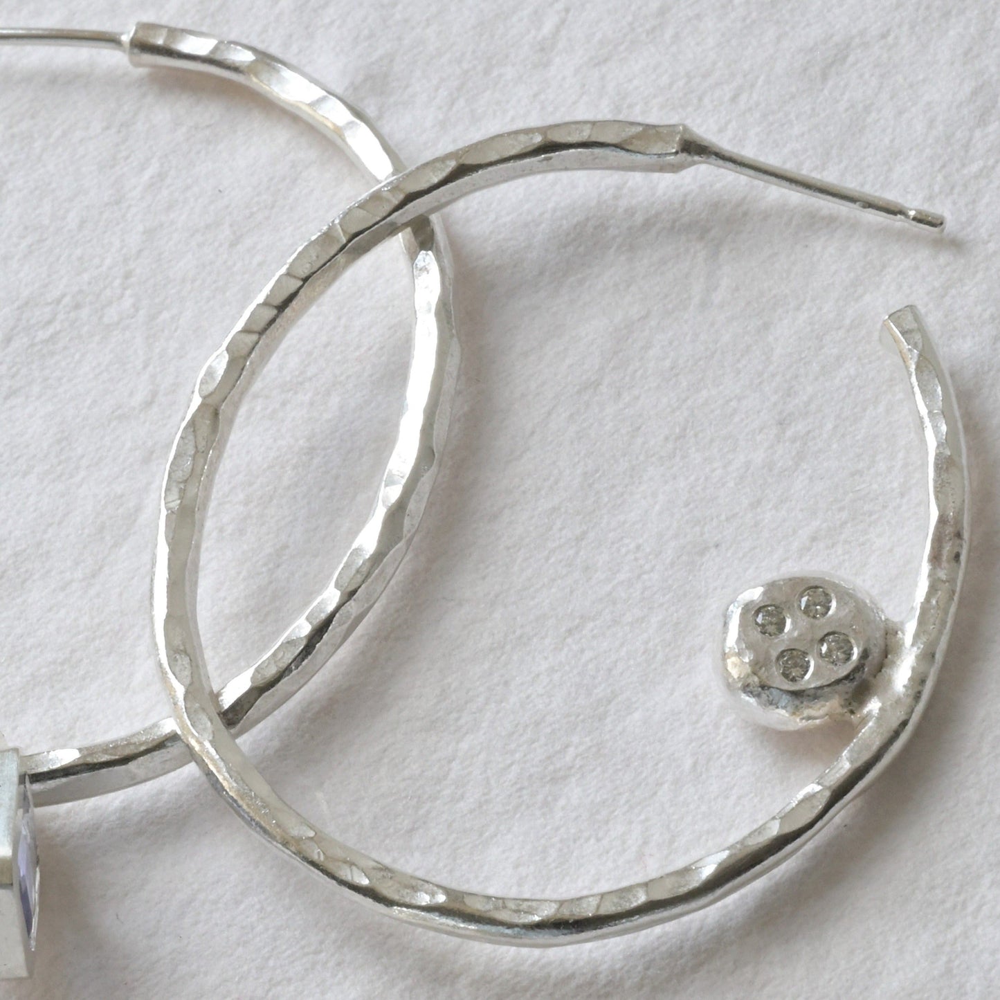 handmade sterling silver hoops with diamonds and tanzanite's photographed on white. Handmade fine jewellery by Madeleine.