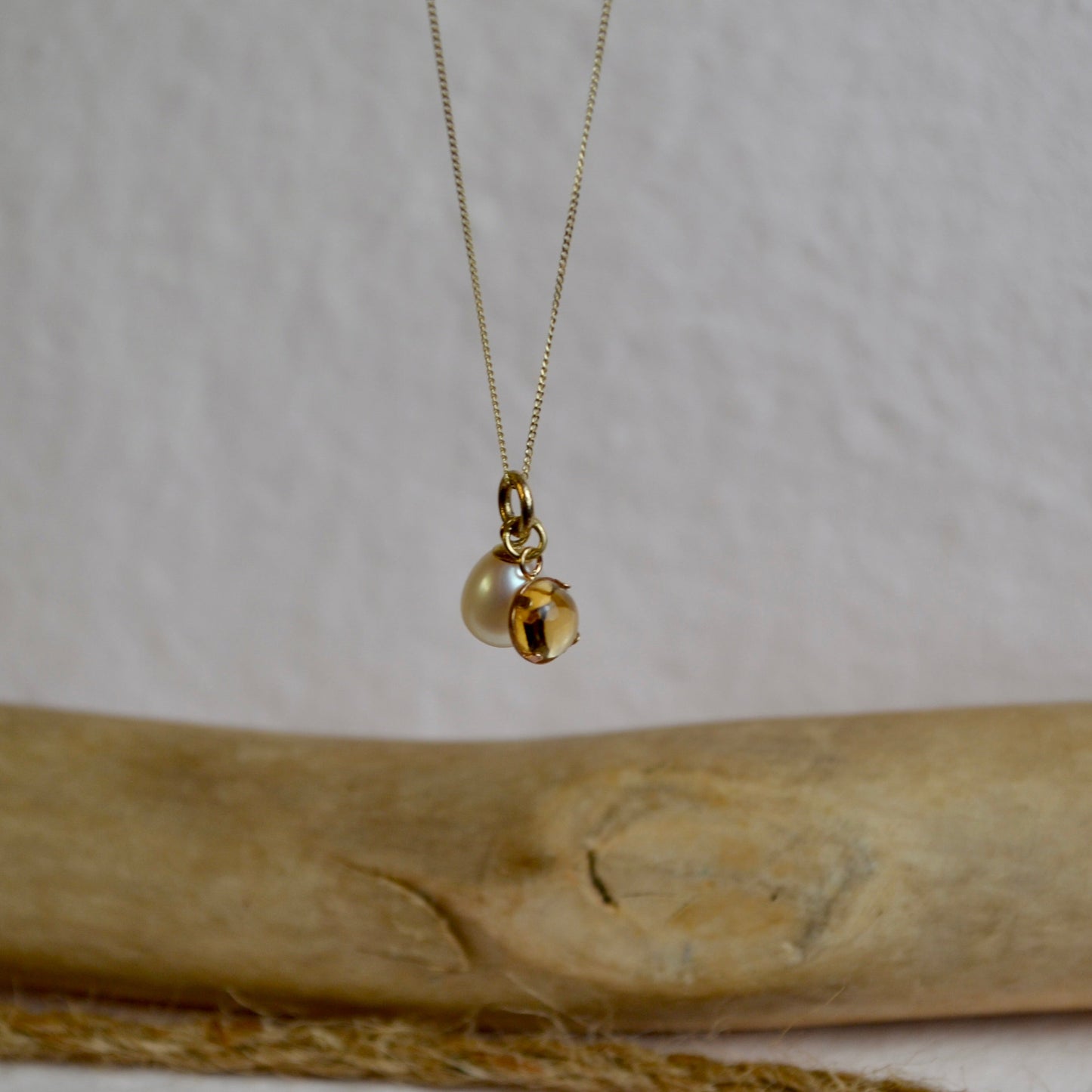 Gold necklace with a pendant on a wooden surface