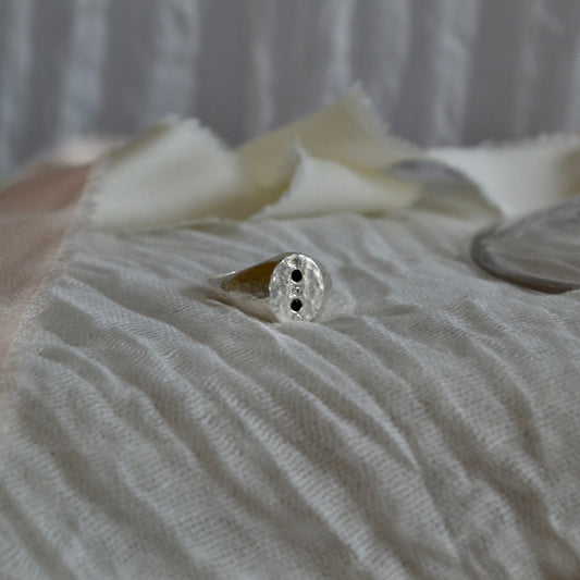Close-up of a ring on a textured surface with a blurred background