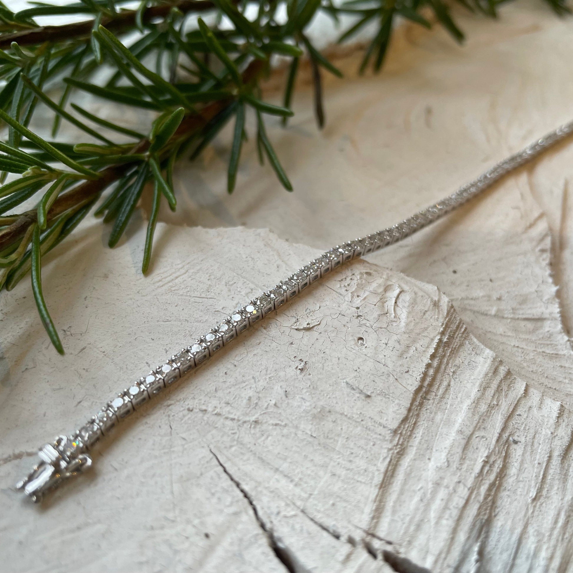 diamond tennis bracelet pictured on white wood in the Cotswold's. Handmade fine jewellery by Madeleine.
