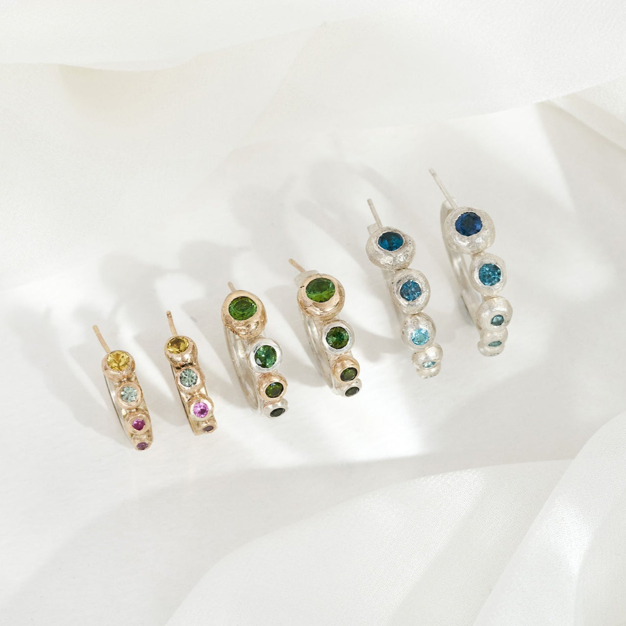Set of colorful gemstone earrings on a white background