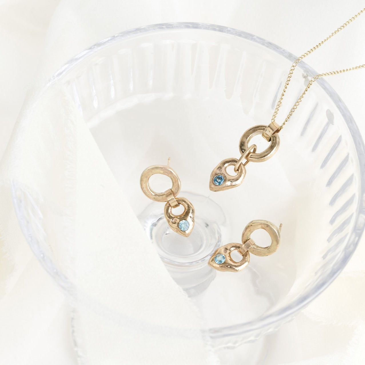 Gold necklace with heart-shaped pendants on a white background