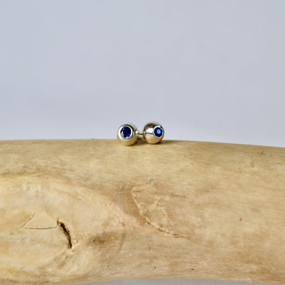 Gold earrings with blue stones on a wooden surface