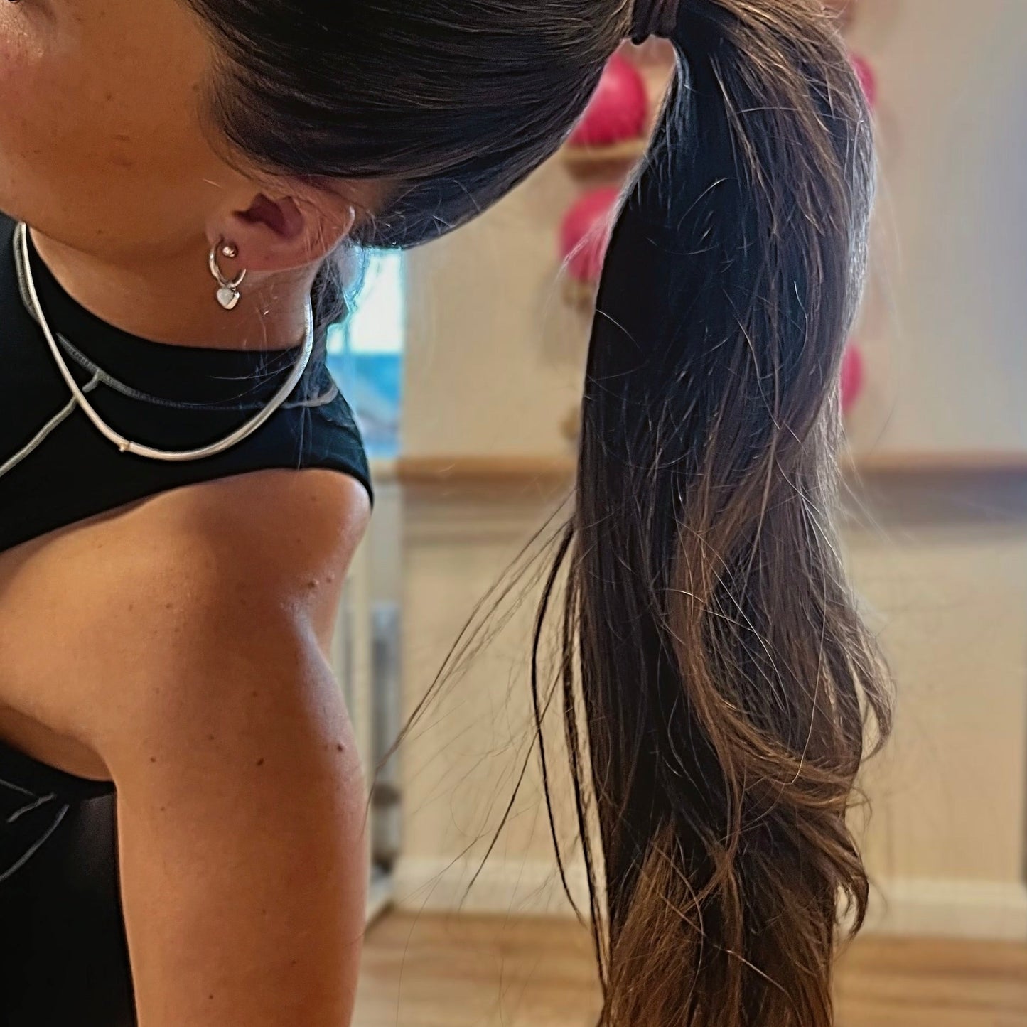 Person with a ponytail wearing earrings indoors