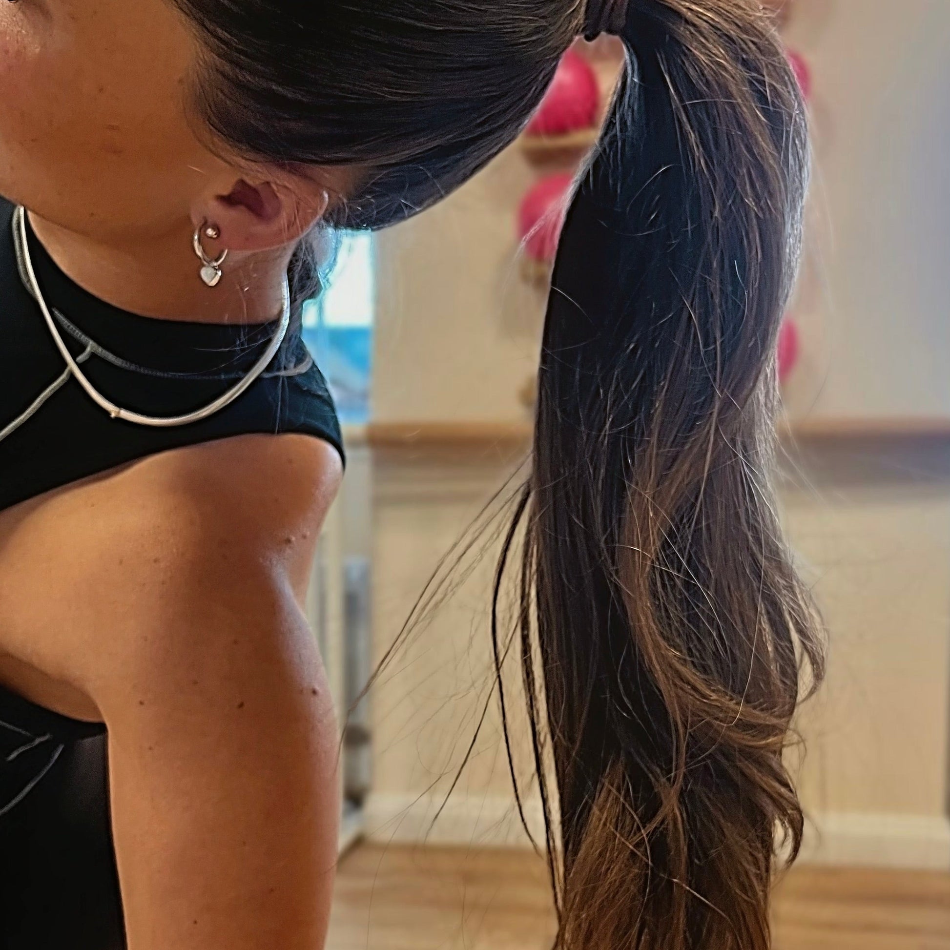 Person with a ponytail wearing earrings indoors