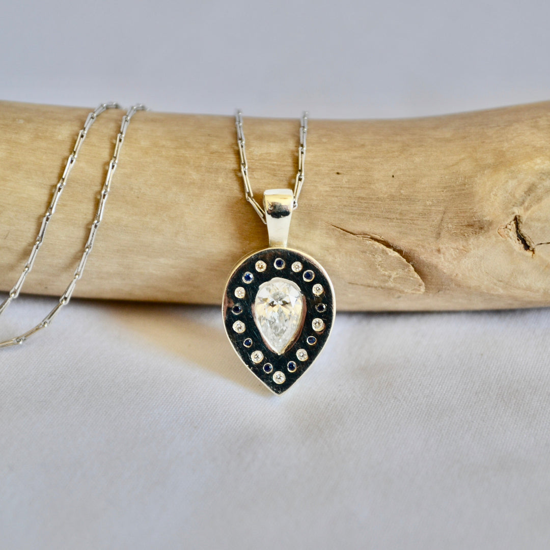 Necklace with a heart-shaped pendant on a piece of driftwood