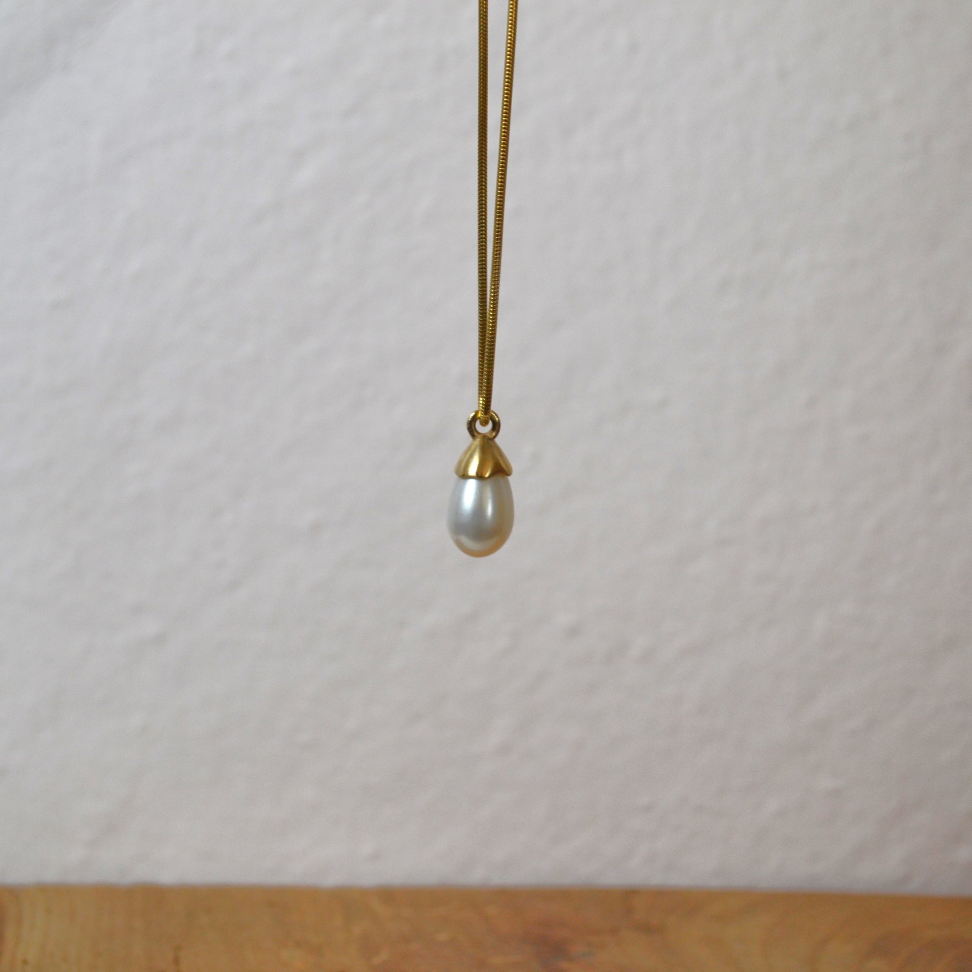 Pearl necklace with gold clasp on a white background