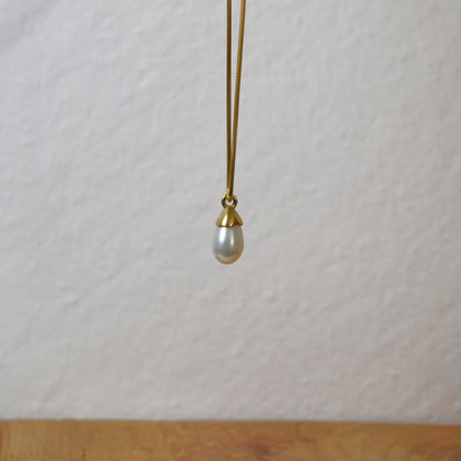 Pearl necklace with gold clasp on a white background