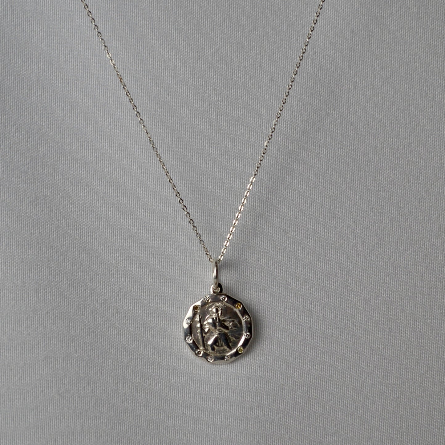 Silver necklace with a pendant on a gray background