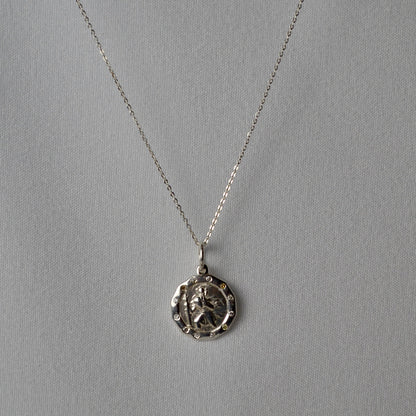Silver necklace with a pendant on a gray background