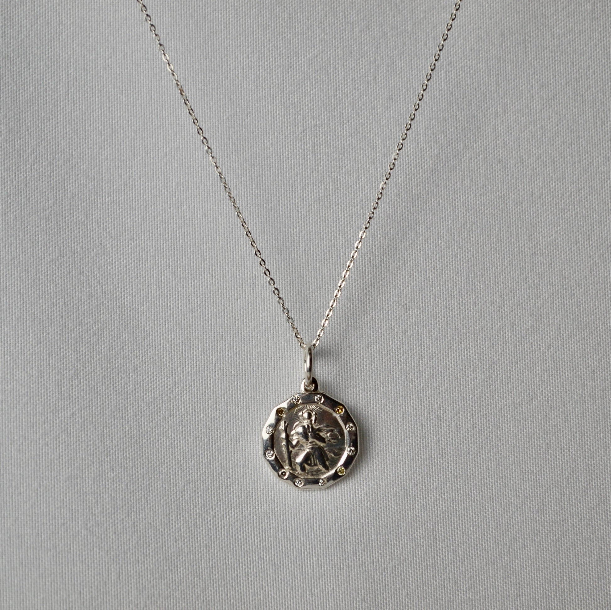 Silver necklace with a pendant on a gray background