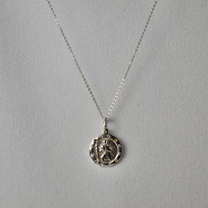 Silver necklace with a pendant on a gray background