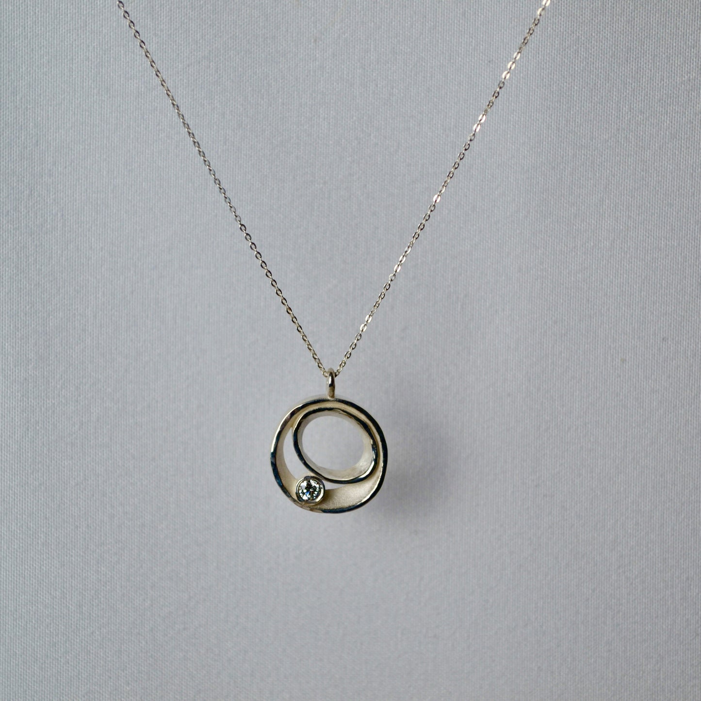 Necklace with a circular pendant on a gray background