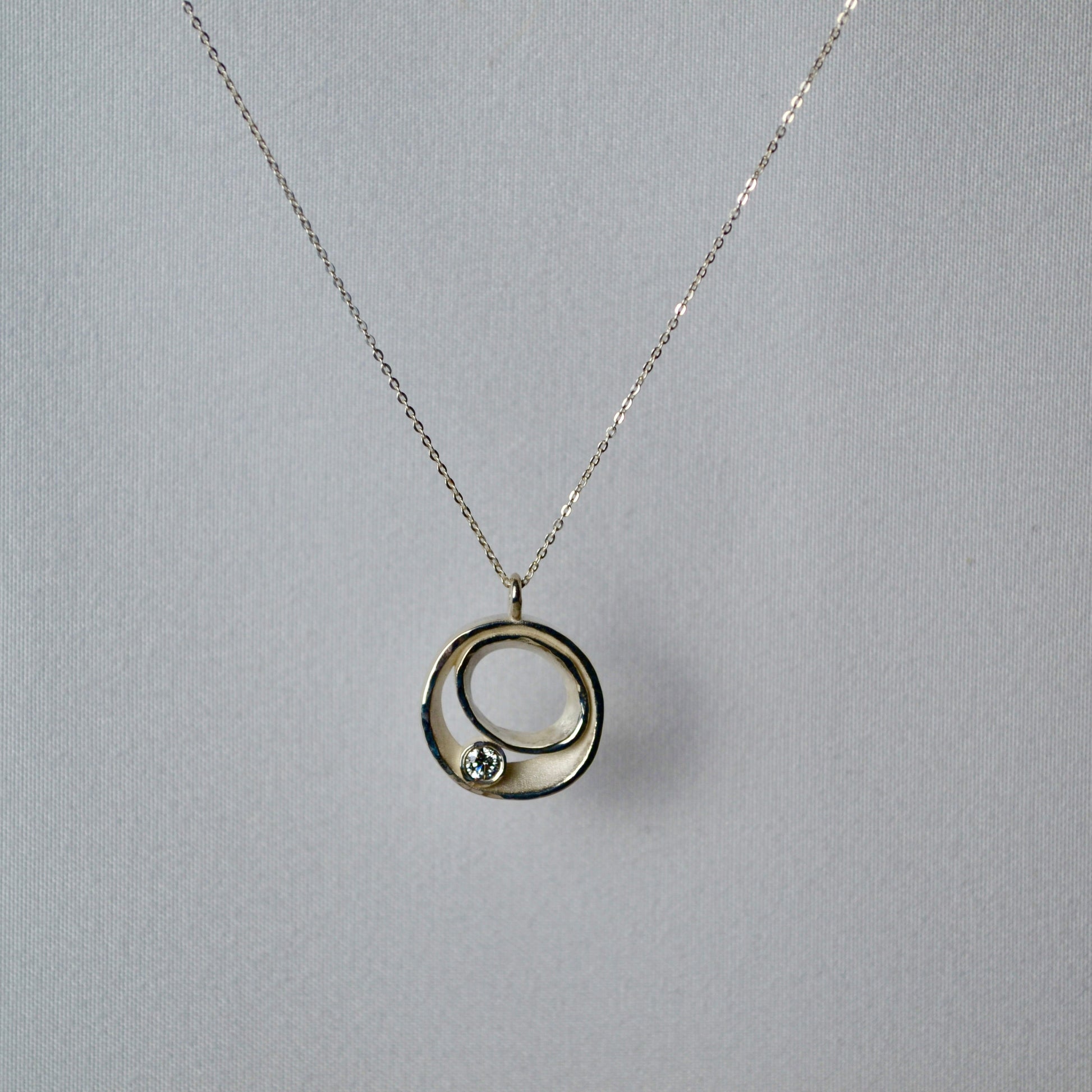 Necklace with a circular pendant on a gray background