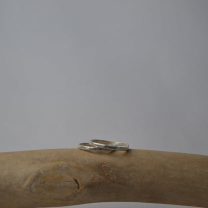 Silver ring on a wooden branch with a plain background
