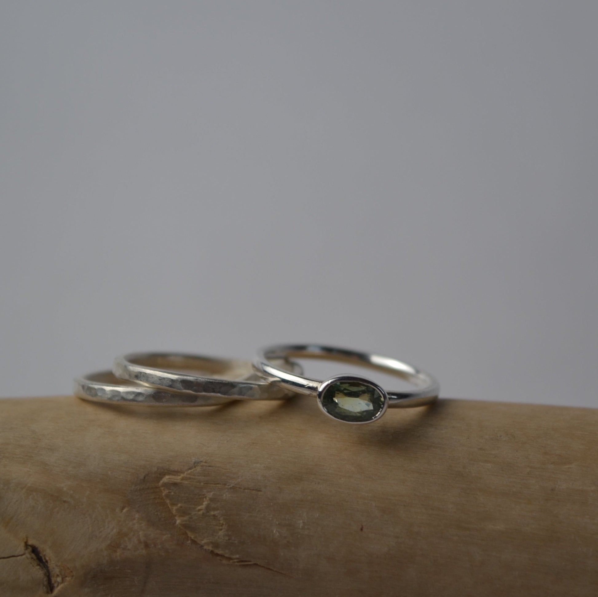 Silver ring with green stone on a textured surface