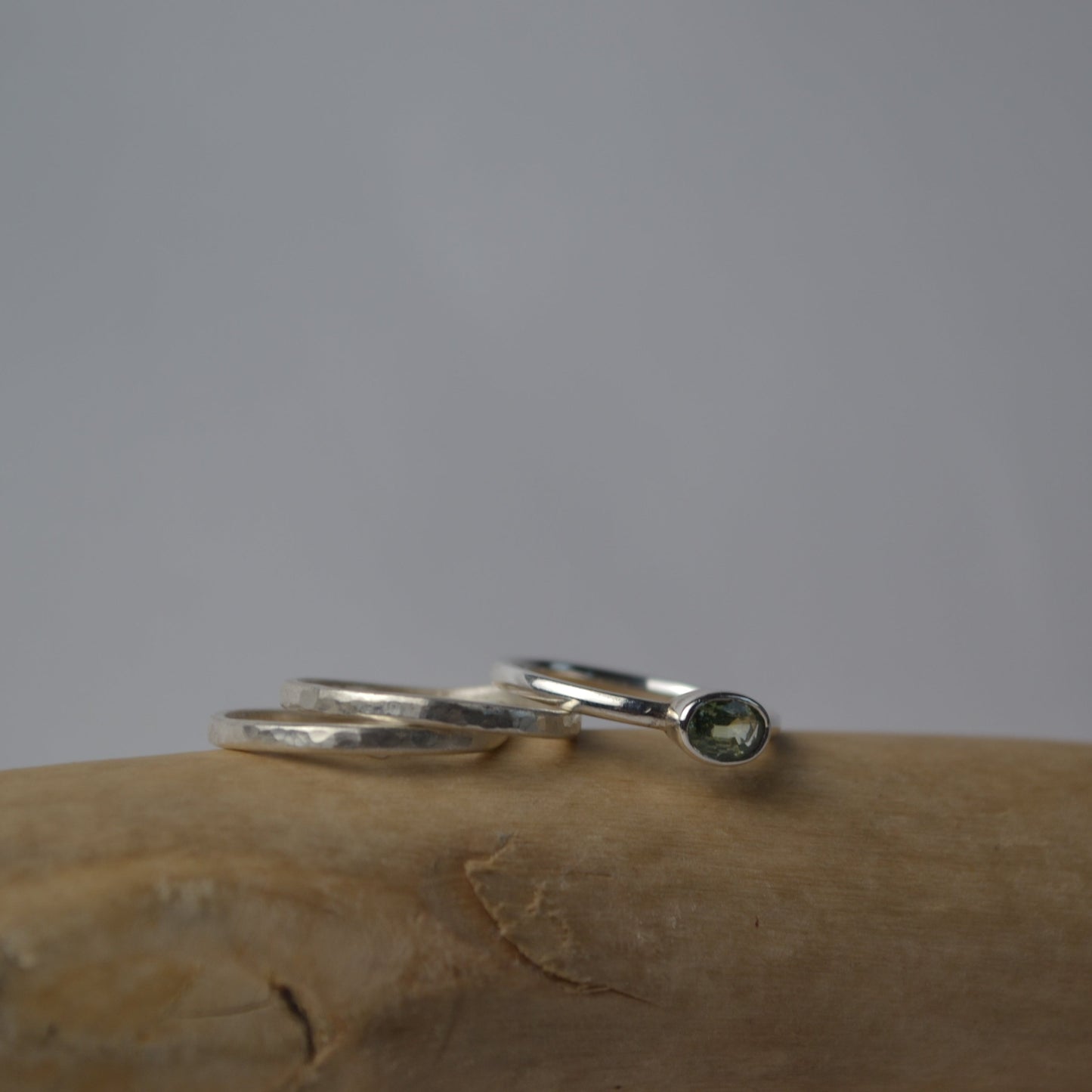 Silver ring with a green gemstone on a textured surface