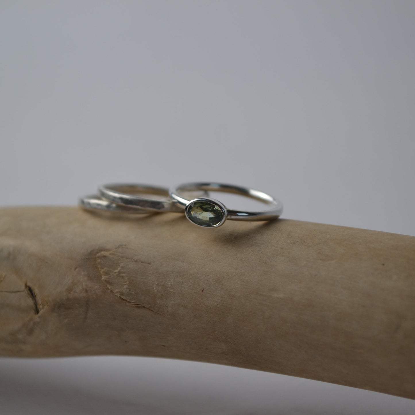 Two silver rings with gemstones on a wooden surface