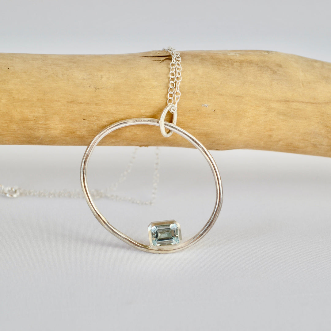 Silver ring with a green gemstone on a white background
