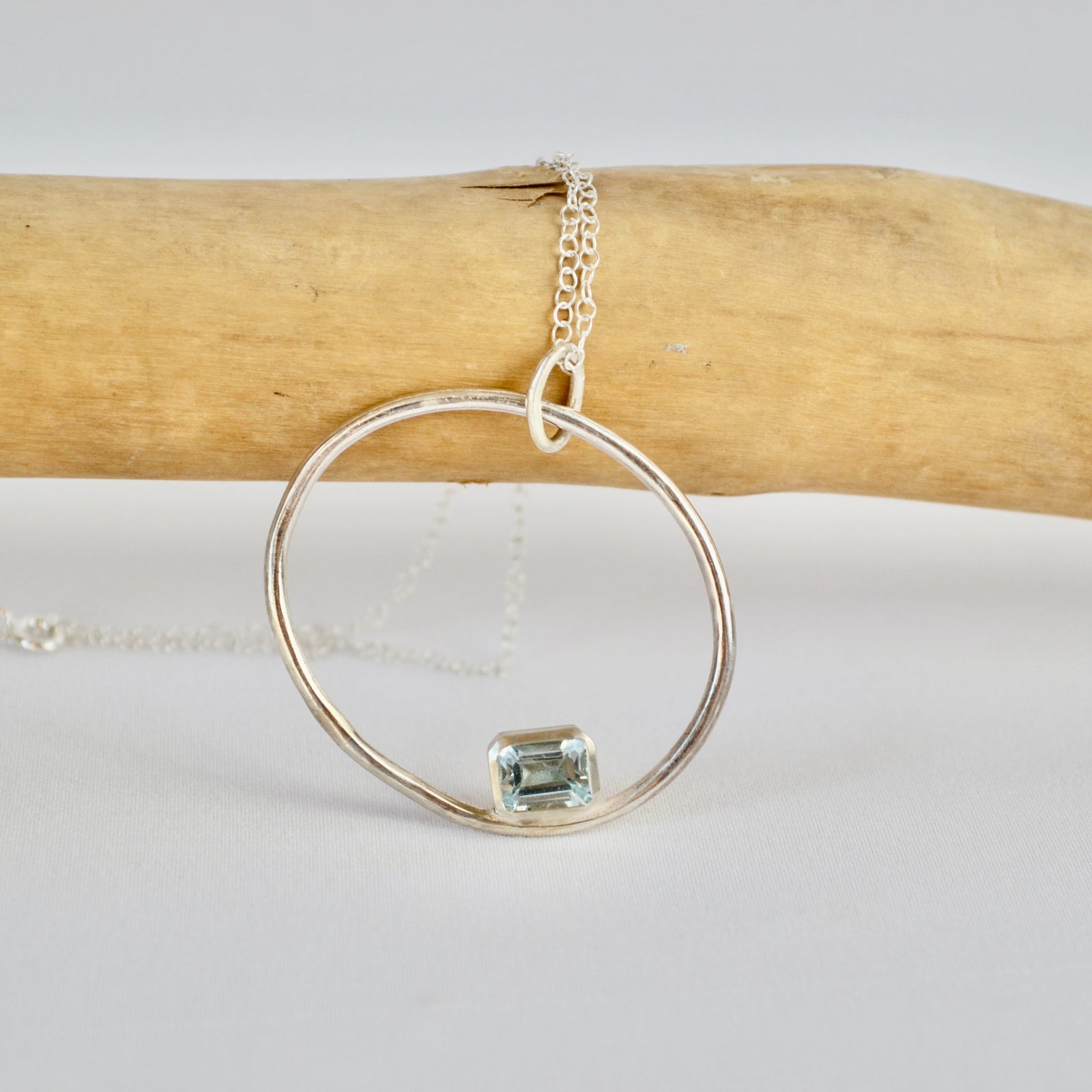Silver ring with a green gemstone on a white background