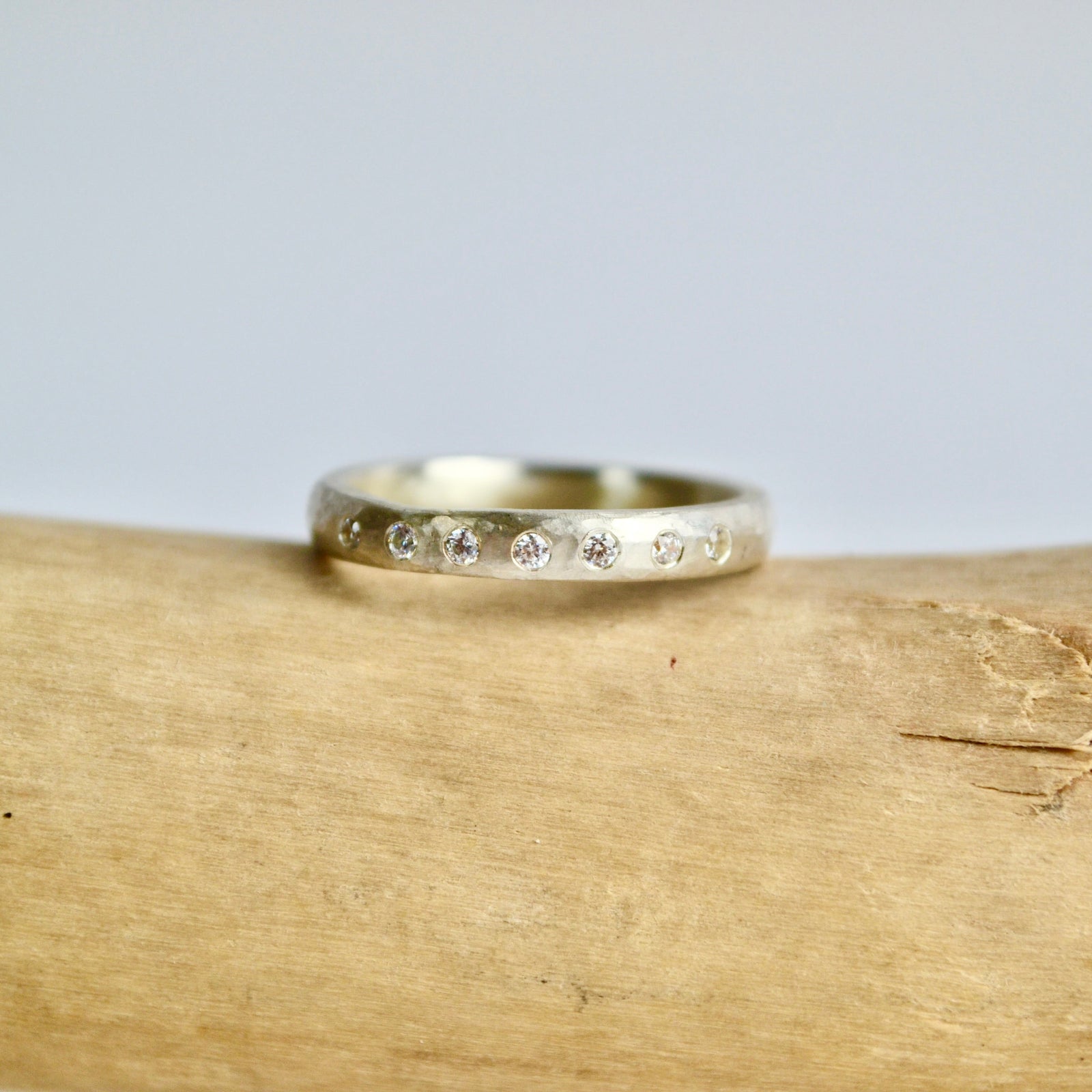 Gold ring with small diamonds on a wooden surface