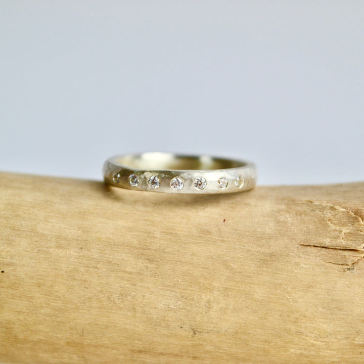Gold ring with small diamonds on a wooden surface