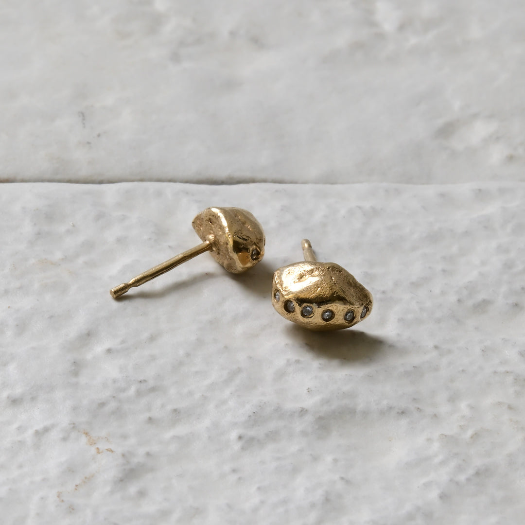 diamond gold studs pictured on white brick in the Cotswold&