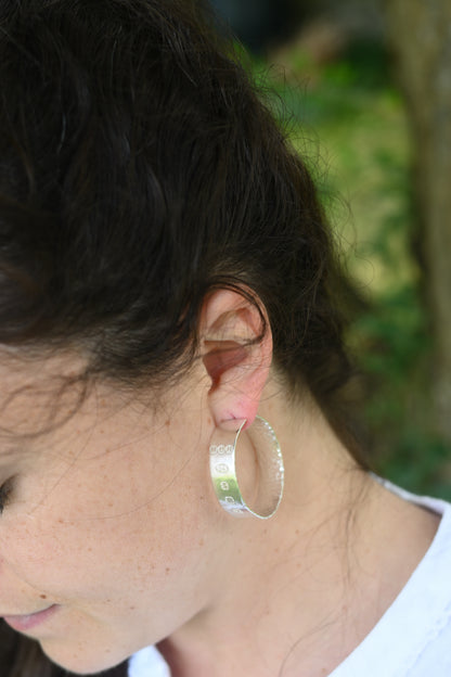 madeleine wearing handmade silver hoops, hallmarked. In the garden.