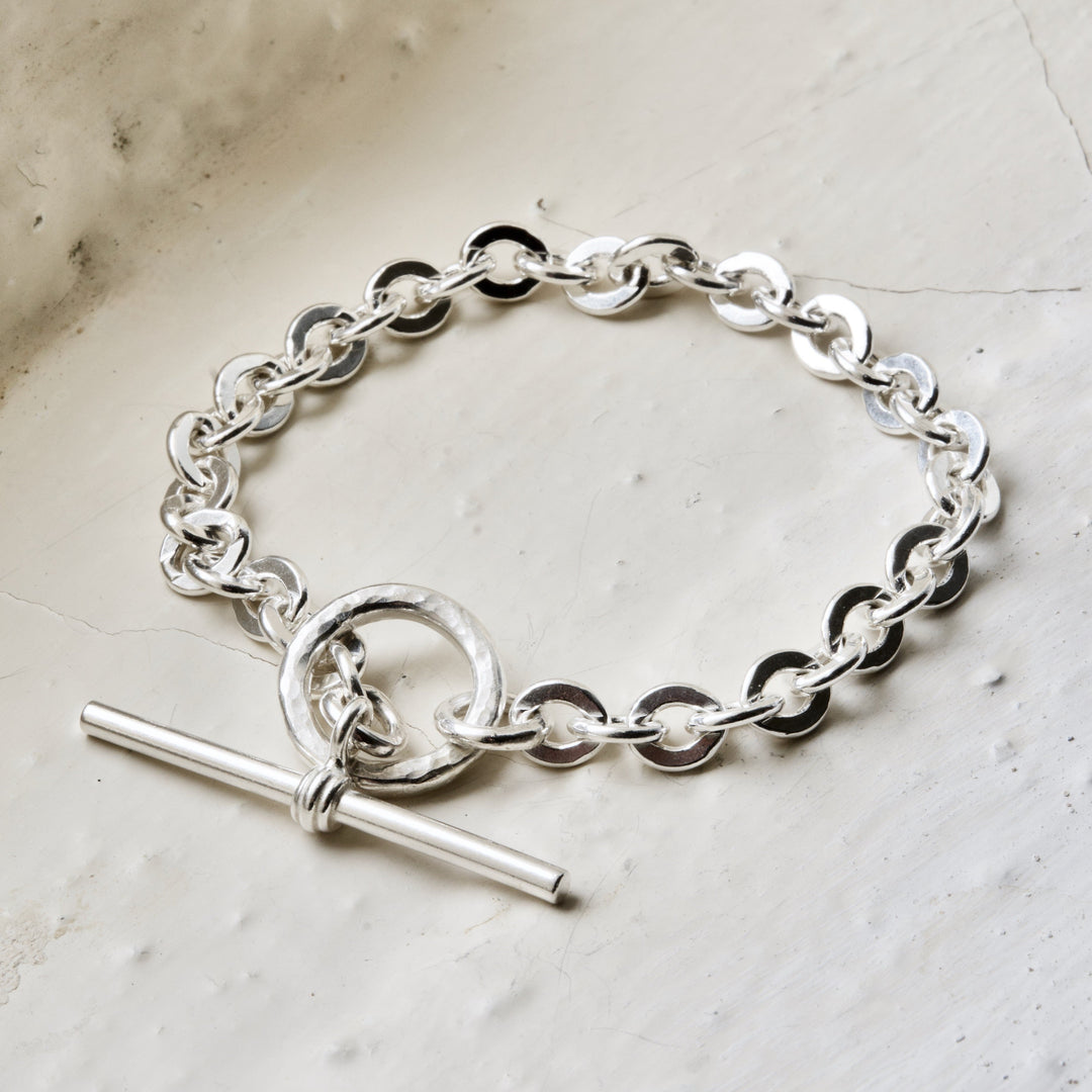A sterling silver toggle bracelet with a double-tone clasp and interlinked chains.
