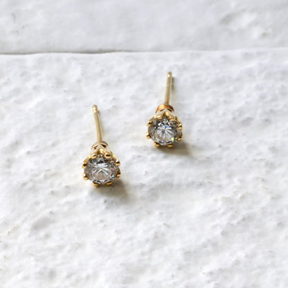 18ct yellow gold and diamond studs, photographed on white Cotswold stone. handmade fine jewellery by Madeleine.