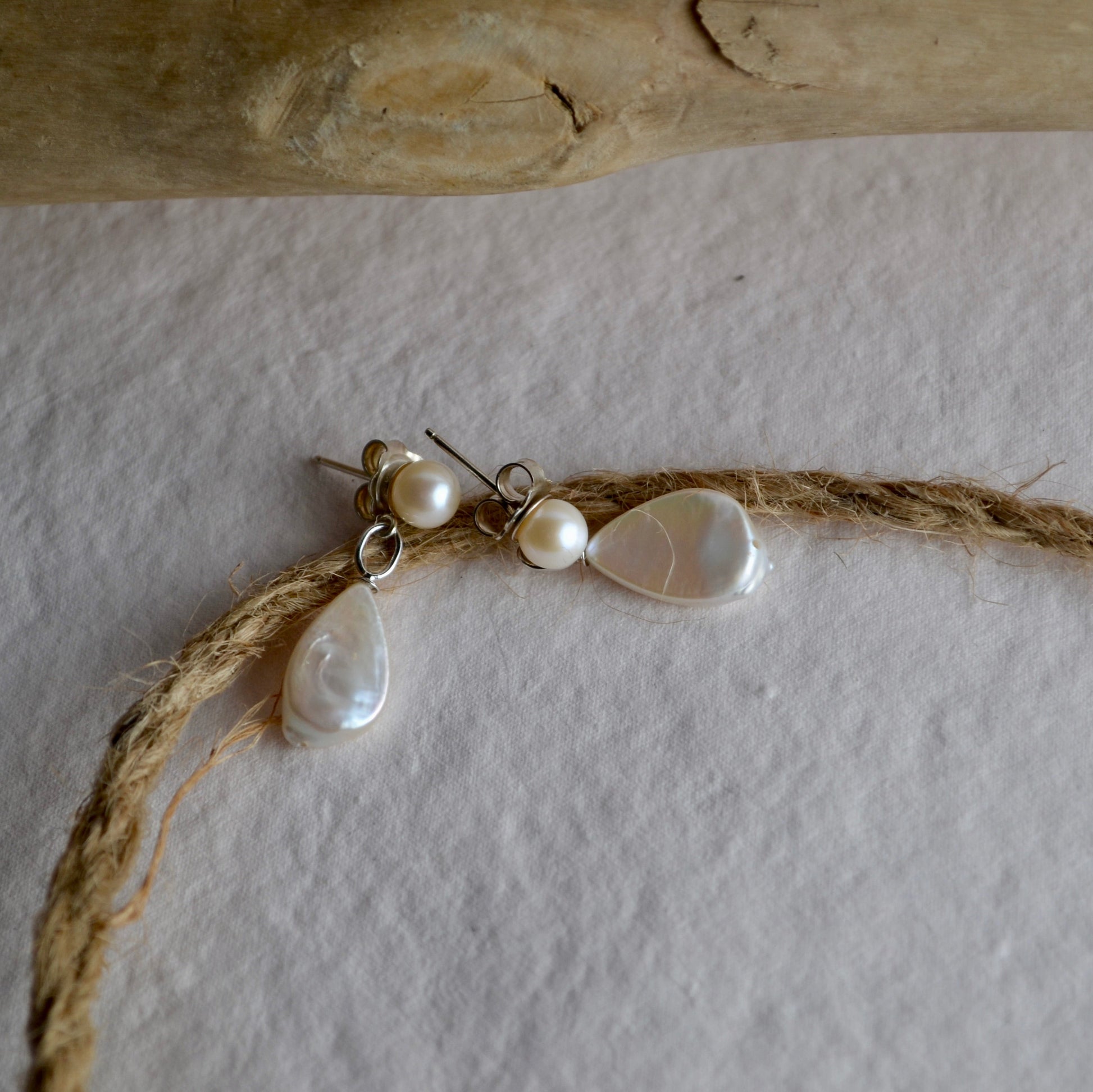 Pearl earrings on a string with a stone background