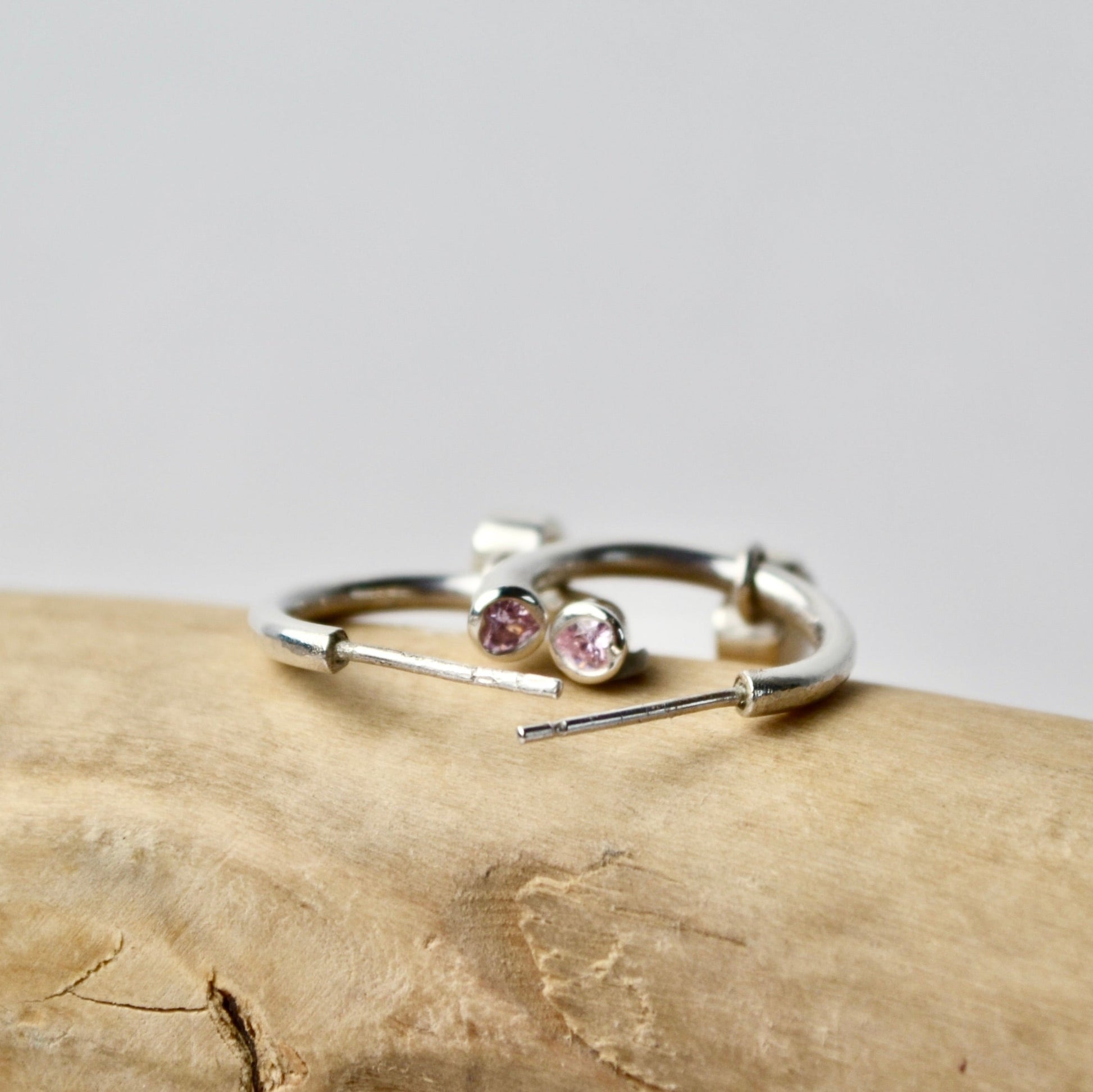 Silver ring with gemstones on a wooden surface