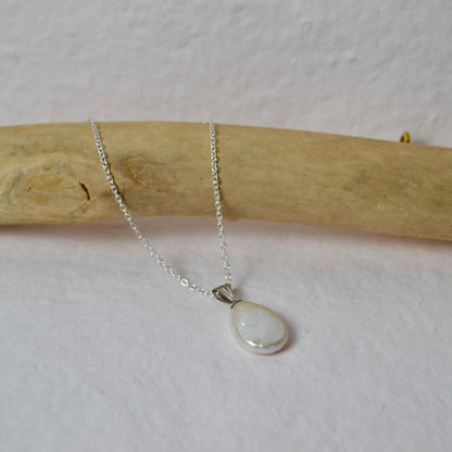 Silver necklace with a teardrop-shaped pendant on a white background