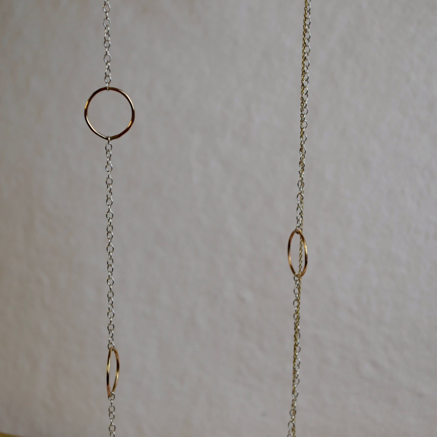 Gold chain with circular links on a light gray background