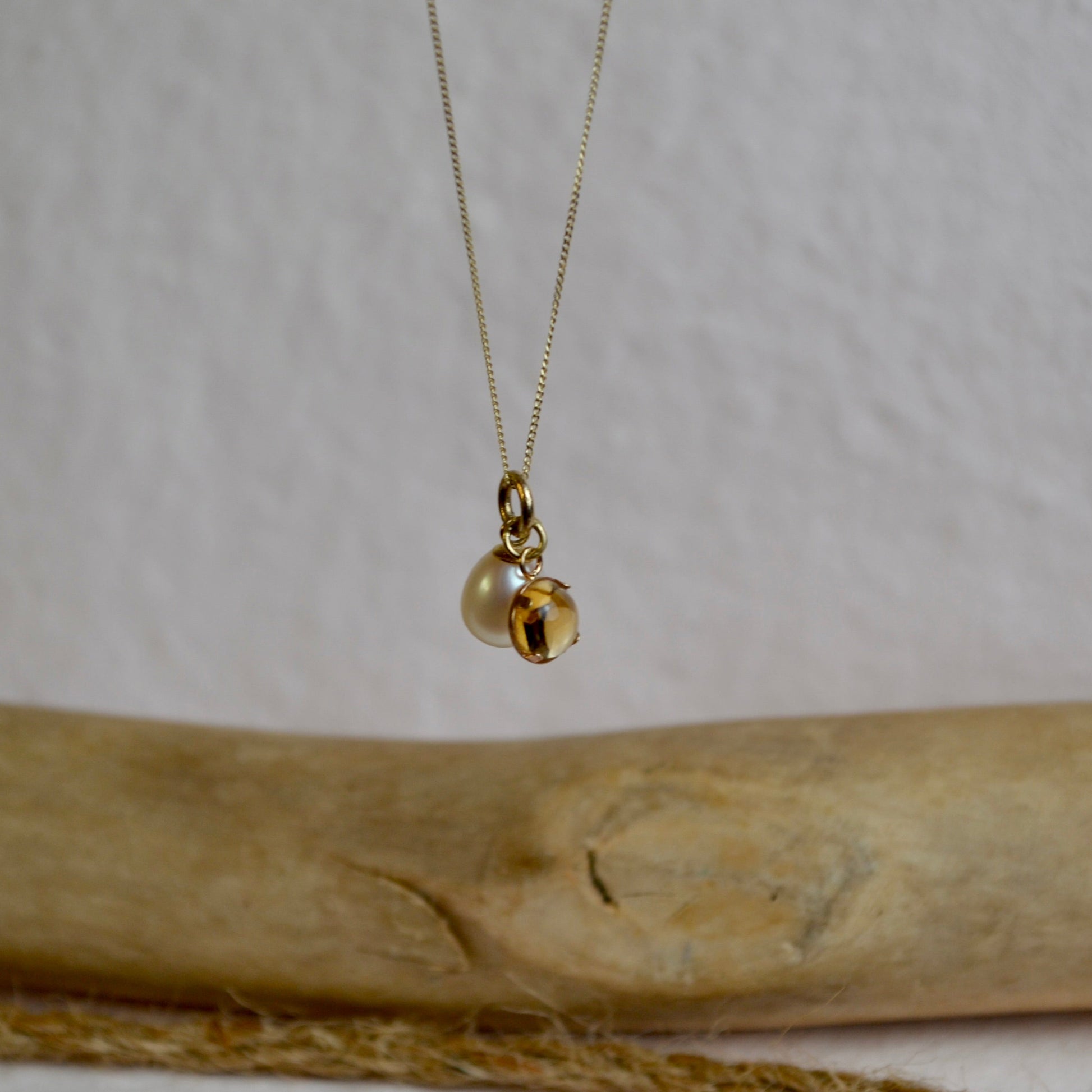 Gold necklace with a pendant on a wooden surface
