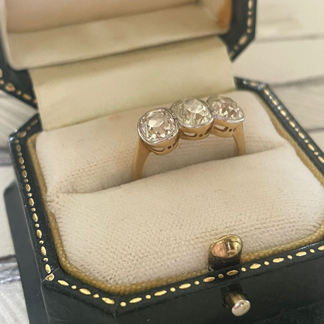 Gold ring with three diamonds in a jewelry box