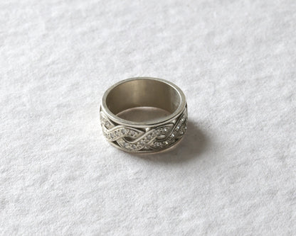 white gold celtic twist ring with diamonds pictured on white.