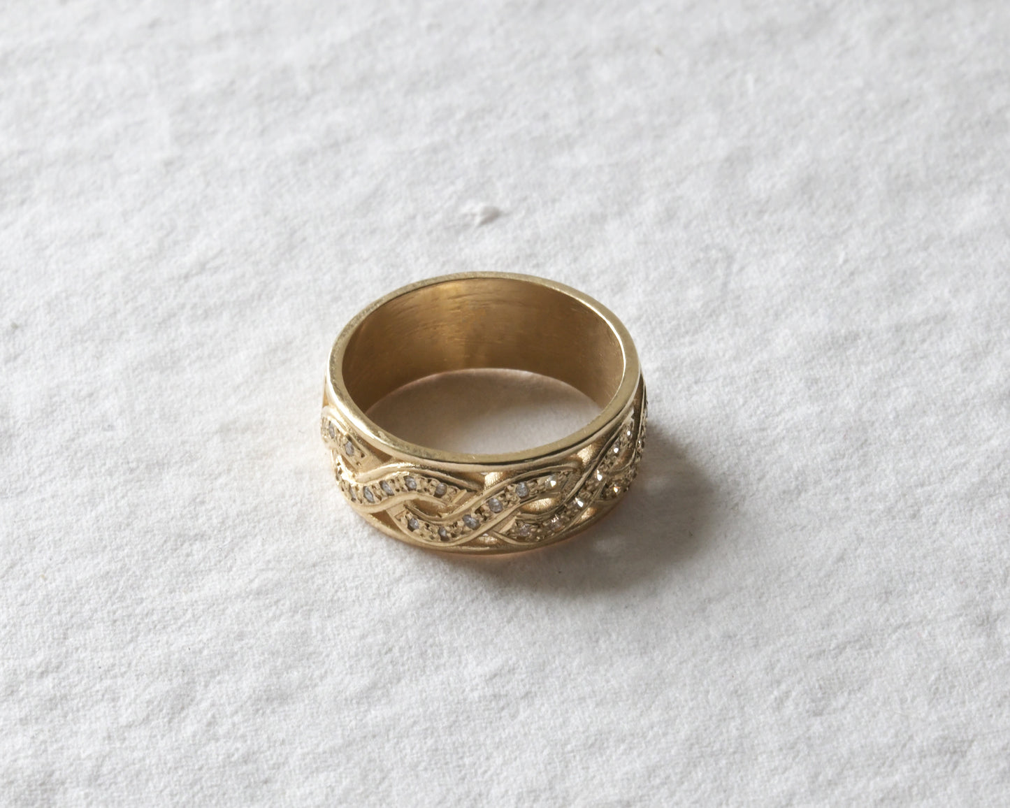 celtic diamond twist ring with diamonds pictured on white.