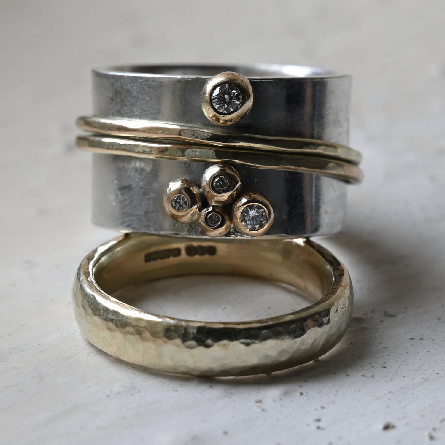 silver and gold diamond spinning ring stacked on a gold wedding band. Handmade fine jewellery by Madeleine.