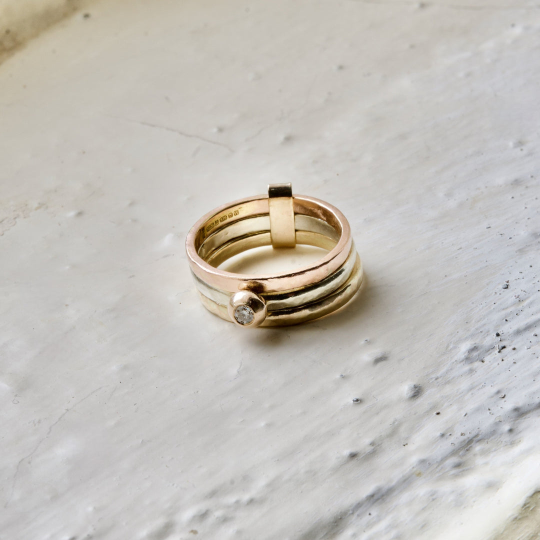 Gold ring with a diamond on a marble surface