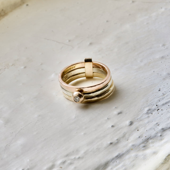 Gold ring with a diamond on a marble surface