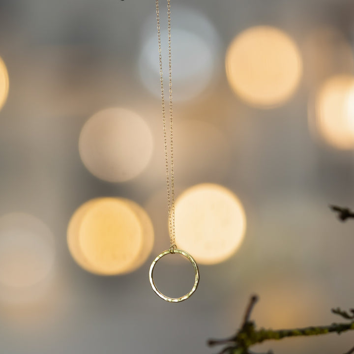 handmade 18ct yellow gold circle necklace hanging beautifully with brugh lights.