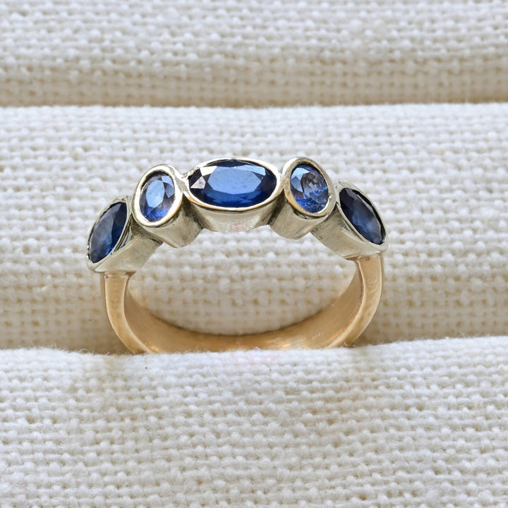 blue sapphire and gold engagement ring on white 